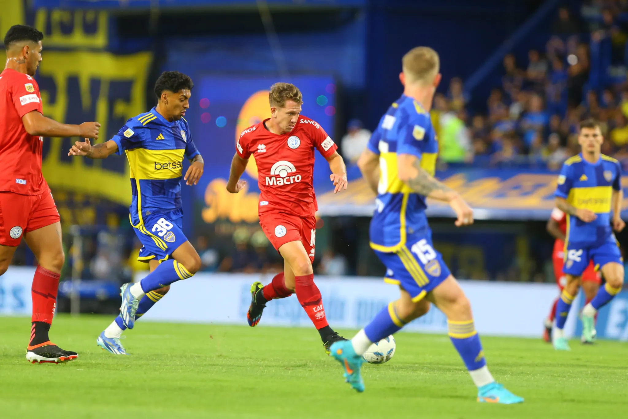 Rolón gambetea rodeado de jugadores de Boca